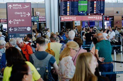 Passagiere warten in einem Terminal am Berliner Flughafen BER