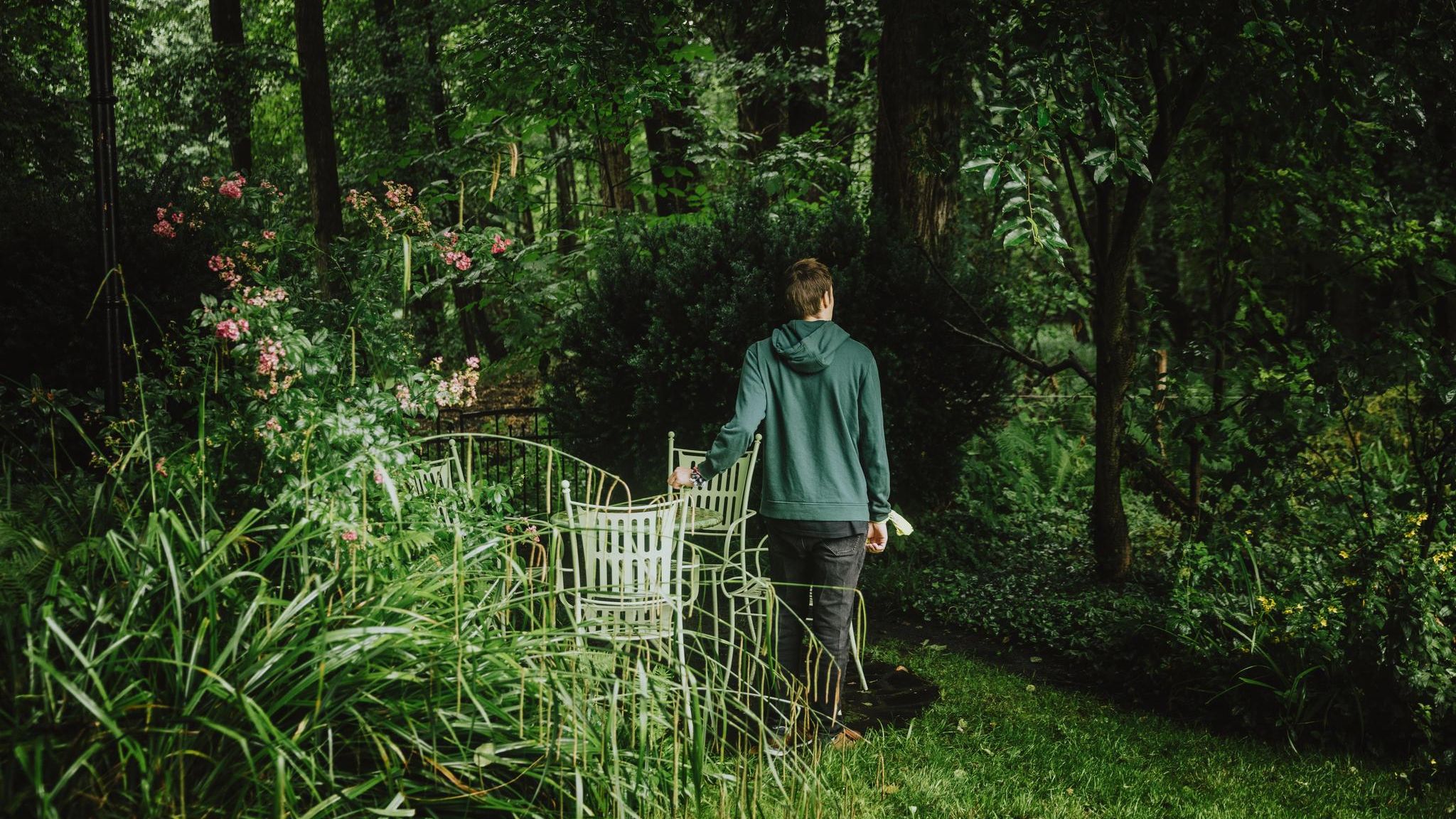 Schizophrenie: ein junger Mann steht in einem Garten