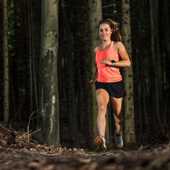 Joggen im Dunkeln: Junge Läuferin im Wald