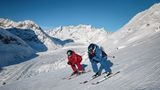 Skifahrer genießen in der Aletsch Arena am Grossen Aletschgletscher weite Pisten und den Blick auf eine beeindruckende Bergkulisse