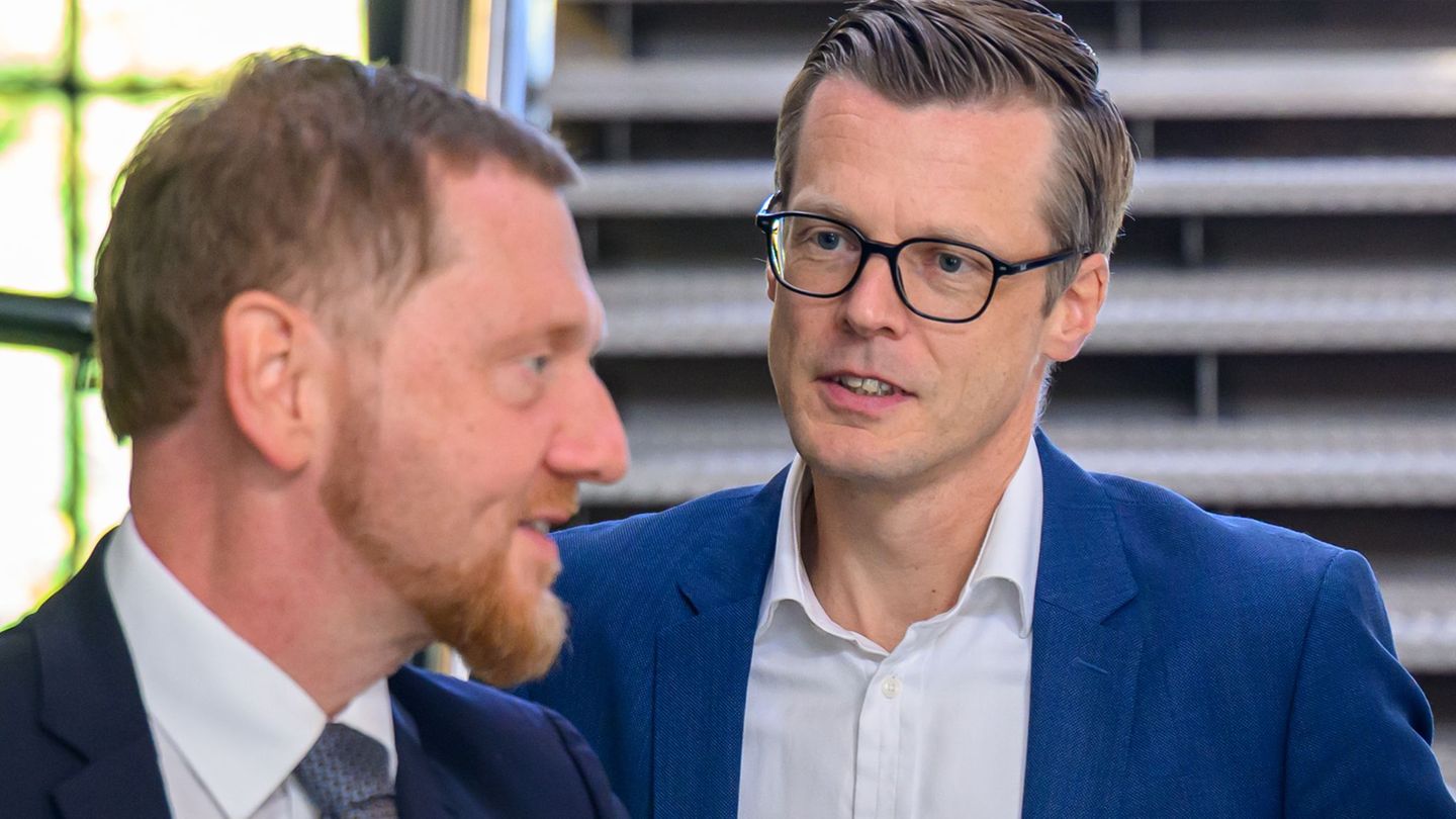 Danny Auerswald (rechts), Sprecher der Geschäftsführung von Volkswagen Sachsen, wird von Ministerpräsident Michael Kretschmer (C