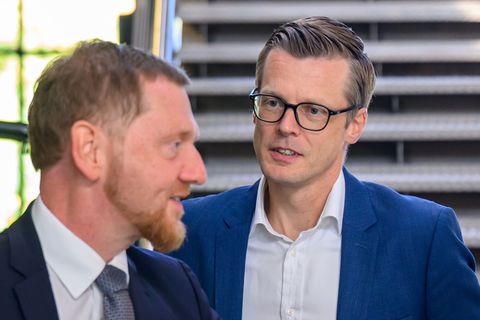 Danny Auerswald (rechts), Sprecher der Geschäftsführung von Volkswagen Sachsen, wird von Ministerpräsident Michael Kretschmer (C