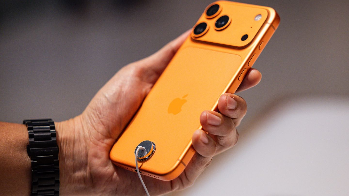 Ein Kunde hält das iPhone 17 Pro Max in Orange im Apple Store