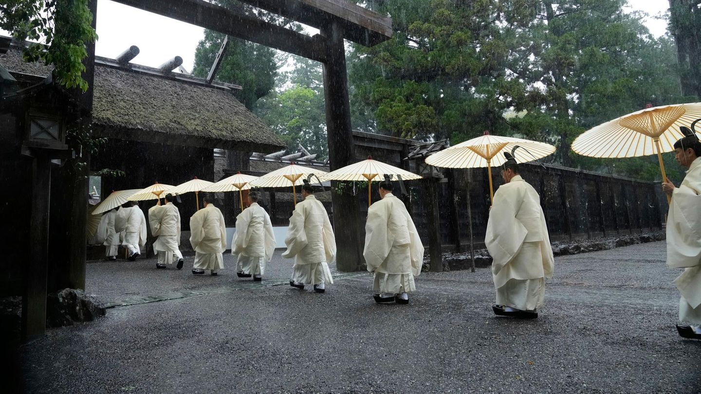 Ise, Japan. Shinto-Priester marschieren in den Hauptpalast von Toyoukedaijingu, auch bekannt als das "Äußere Heiligtum", des Ise-Jingu-Schrein-Komplexes. Bei der sogenannten "Shikinen Sengu"-Zeremonie wird die Haupthalle des Schrein auf einem Nebengrundstück komplett neu errichtet, das alte Gebäude wird anschließend im Zuge eines Erneuerungsprozesses verbrannt. Das Prozedere endet 2033