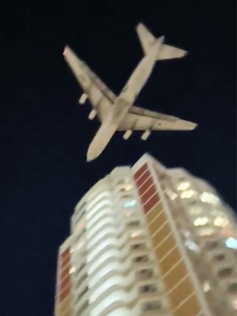 Ein Flugzeug nur knapp über einem Wohngebäude.