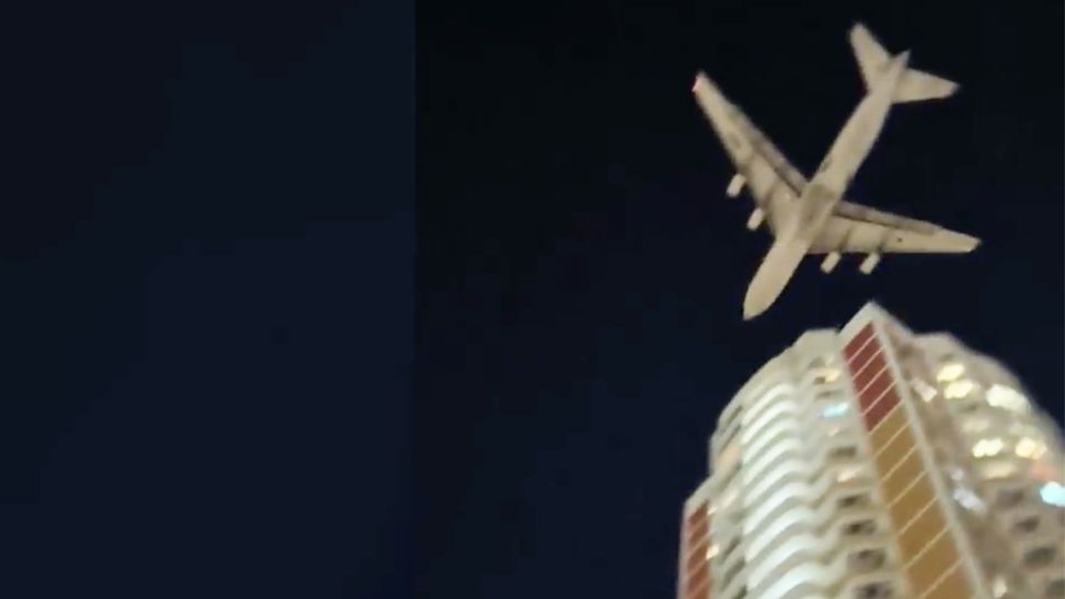Ein Flugzeug nur knapp über einem Wohngebäude.