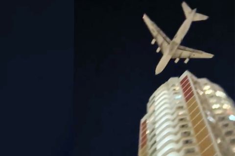 Ein Flugzeug nur knapp über einem Wohngebäude.