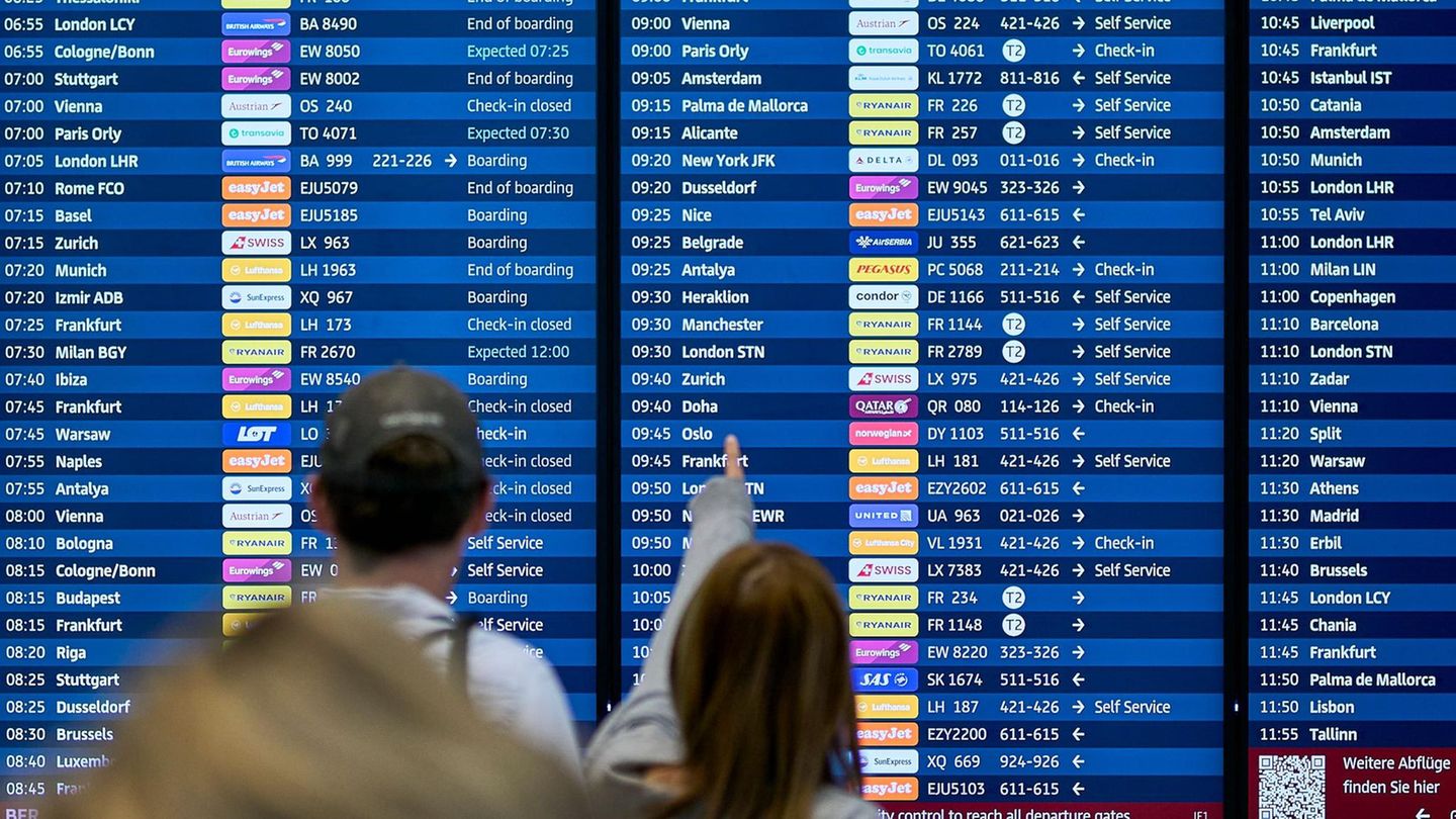 Fluggäste informieren sich an den Abflugtafeln im Terminal 1 des Flughafens Berlin Brandenburg BER