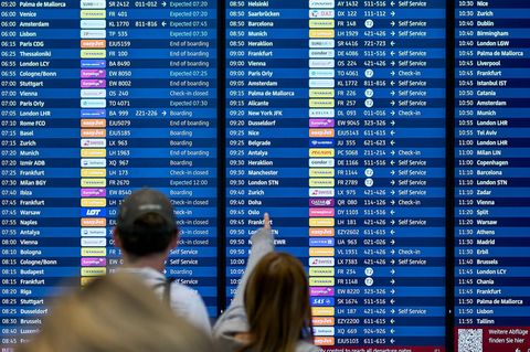 Fluggäste informieren sich an den Abflugtafeln im Terminal 1 des Flughafens Berlin Brandenburg BER