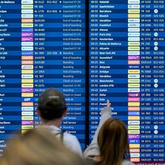 Fluggäste informieren sich an den Abflugtafeln im Terminal 1 des Flughafens Berlin Brandenburg BER