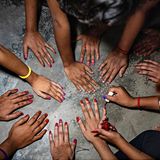 Frauen halten ihre Hände auf Betonfußboden und lackieren sich die Nägel