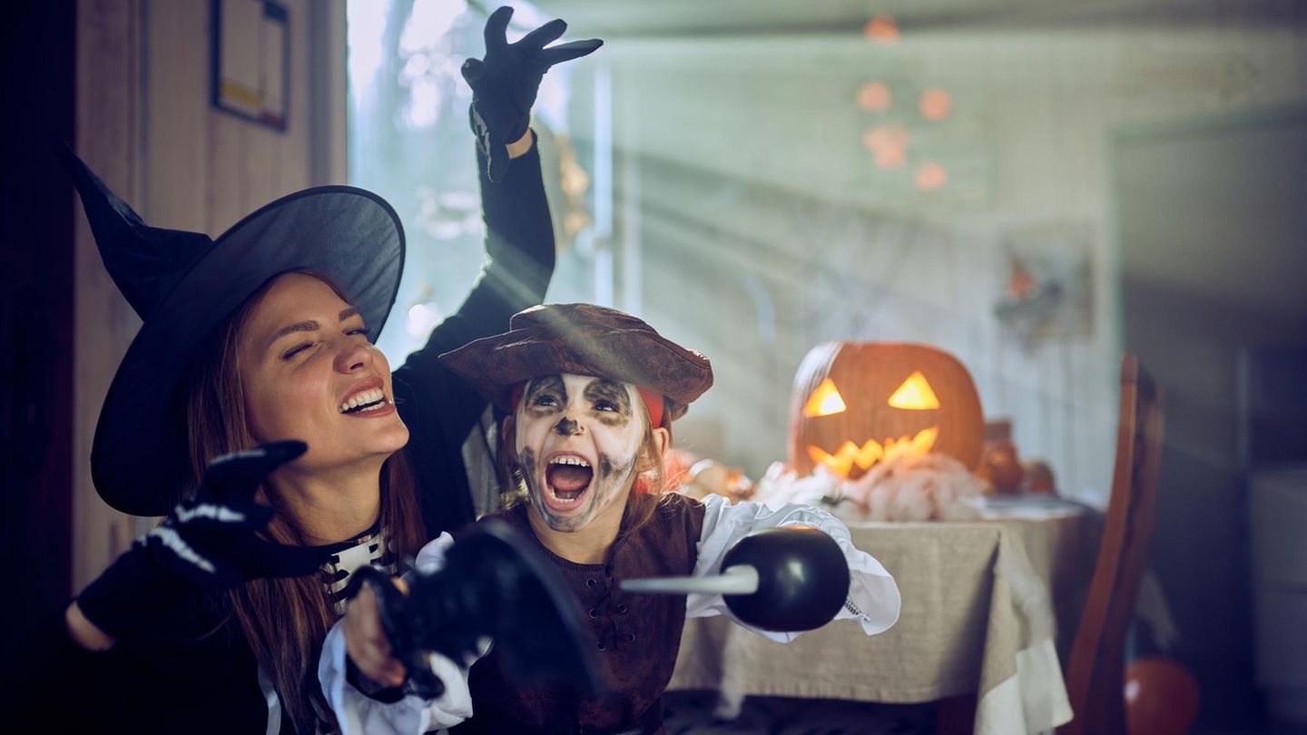 Frau und Kind spielen an Halloween