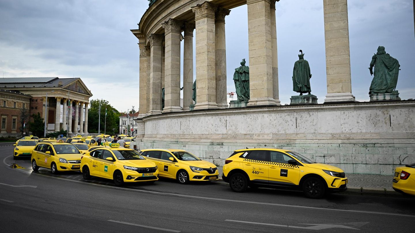 Budapest, Ungarn. Taxis nehmen an einer Protestaktion gegen die geplante Änderung der Taxiverordnung der Hauptstadt auf dem Heldenplatz teil und legen damit Teile des Straßenverkehrs lahm. Die Fahrer demonstrieren gegen geplante Änderungen, wonach die Anzahl an Taxilizenzen gedeckelt werden soll. Gleichzeitig fordern sie die Anpassung der einheitlichen Fahrtkosten, die seit 2021 nicht mehr angehoben wurden