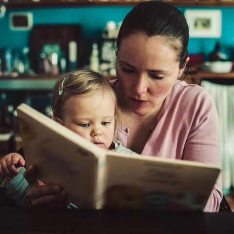 Alleinerziehend: eine Mutter liest ihrem Kleinkind ein Buch vor