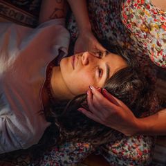 Frau liegt auf dem Schoß von ihrer Freundin