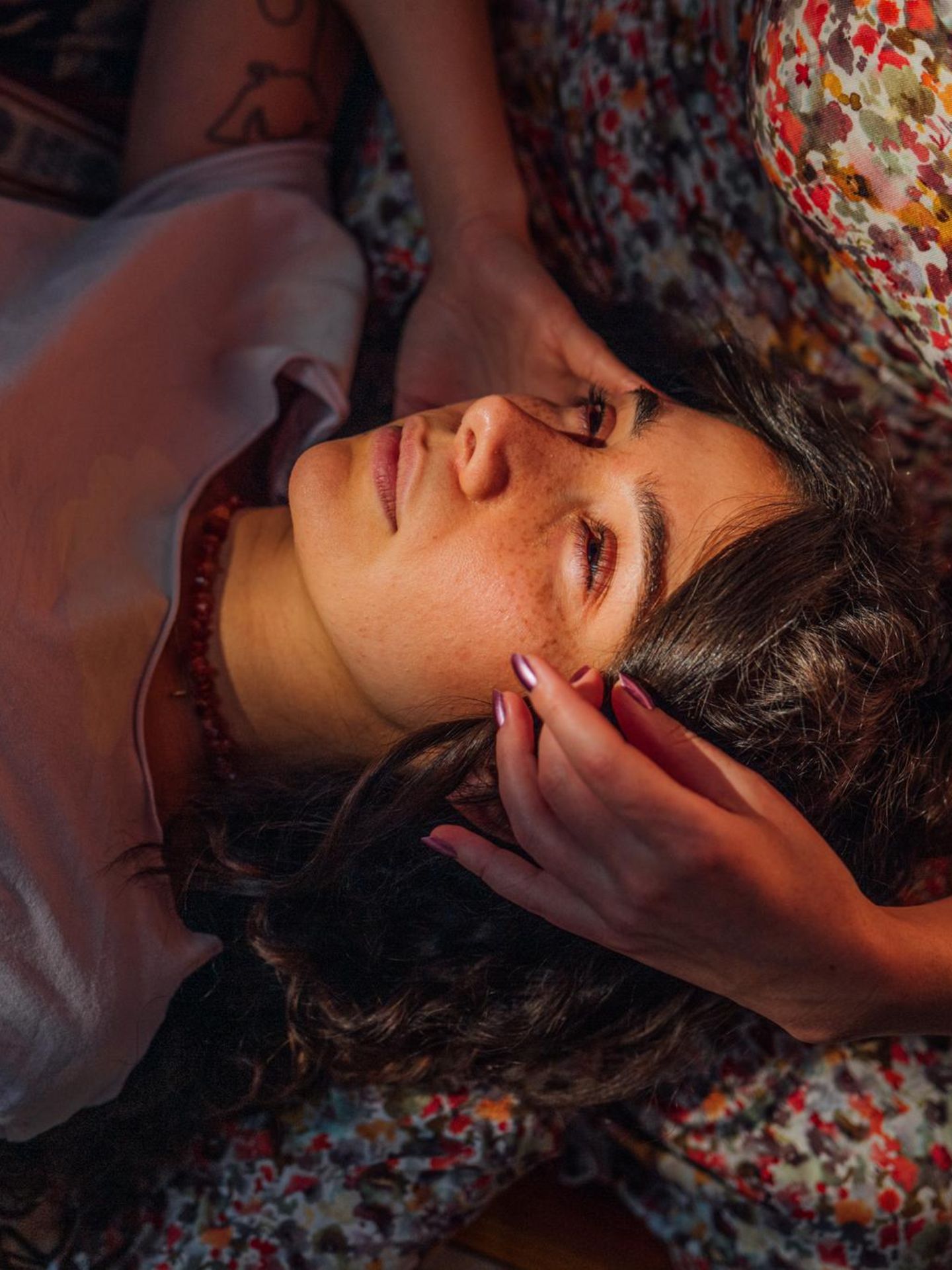 Frau liegt auf dem Schoß von ihrer Freundin