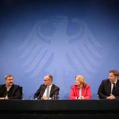Friedrich Merz, Lars Klingbeil, Markus Söder und Bärbel Bas sitzen nebeneinander bei einer Pressekonferenz