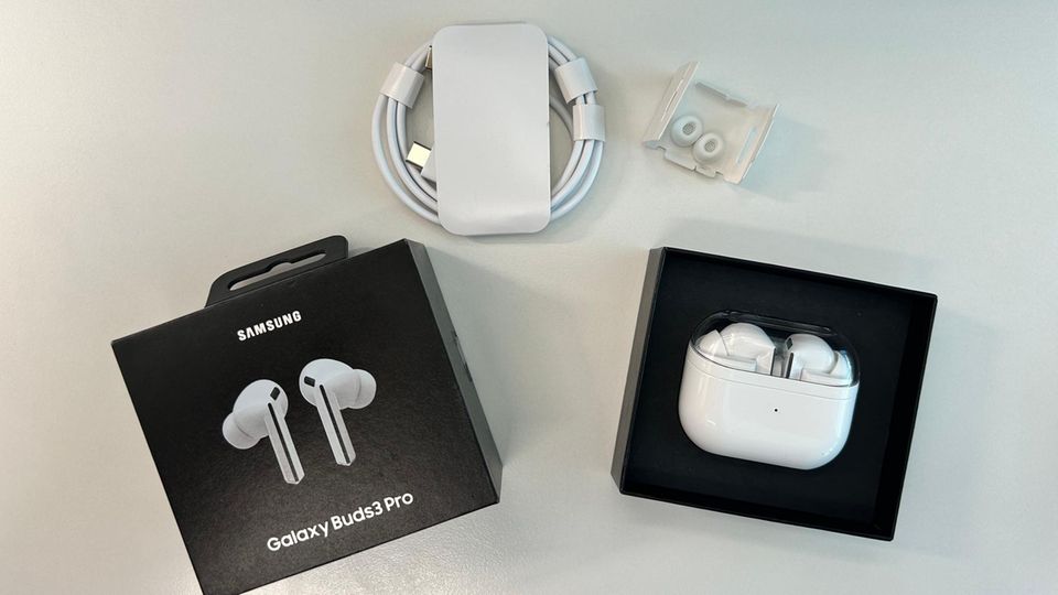 Ladekabel, Buds 3 Pro und Gelpads liegen auf dem Tisch
