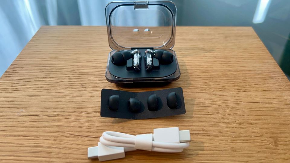 Ladekabel, Nothing Ear (a) Kopfhörer, Case und Gelpads liegen auf einem Tisch