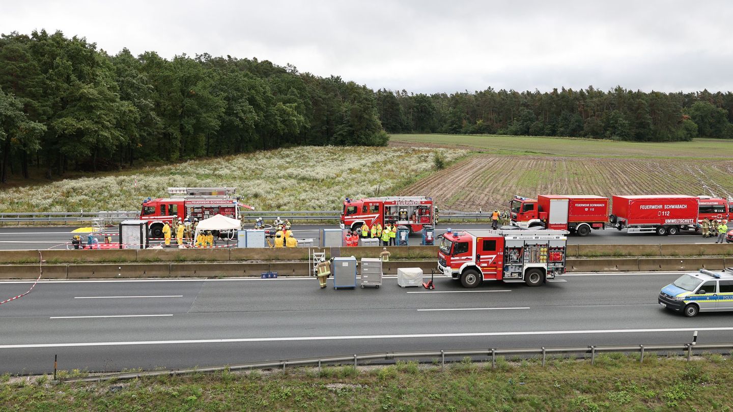 Feuerwehrkräfte untersuchten die ausgelaufenen Flüssigkeiten am Unfallort. Foto: Daniel Löb/dpa