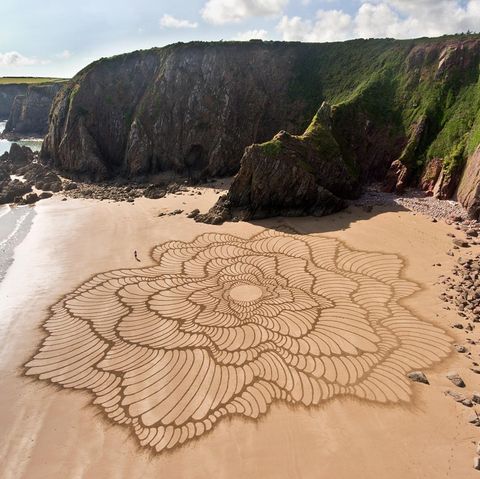 "Fluctuo" heißt dieses Werk des Künstlers Jon Foreman, er zeichnete es 2023 am Strand Lindsway Bay in Wales mit einem Laubrechen in den Sand – freihand, bis auf den Kreis in der Mitte