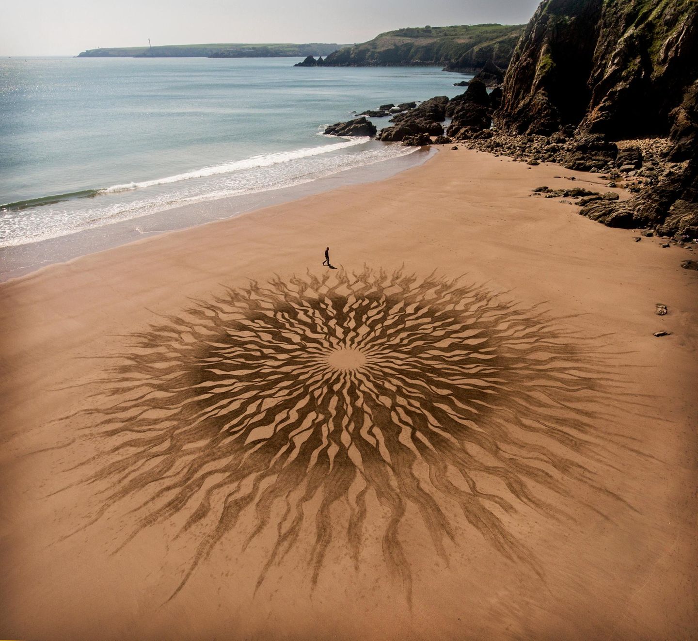 "Dieser Zeichenstil fasziniert mich seit Ewigkeiten", schreibt Land-Artist Jon Foreman über seine mit dem Laubrechen in den Sand gezeichnete "Sonne" am Strand Lindsway Bay in Wales. "Man kann das einfach per Hand zeichnen, ohne Lineal"