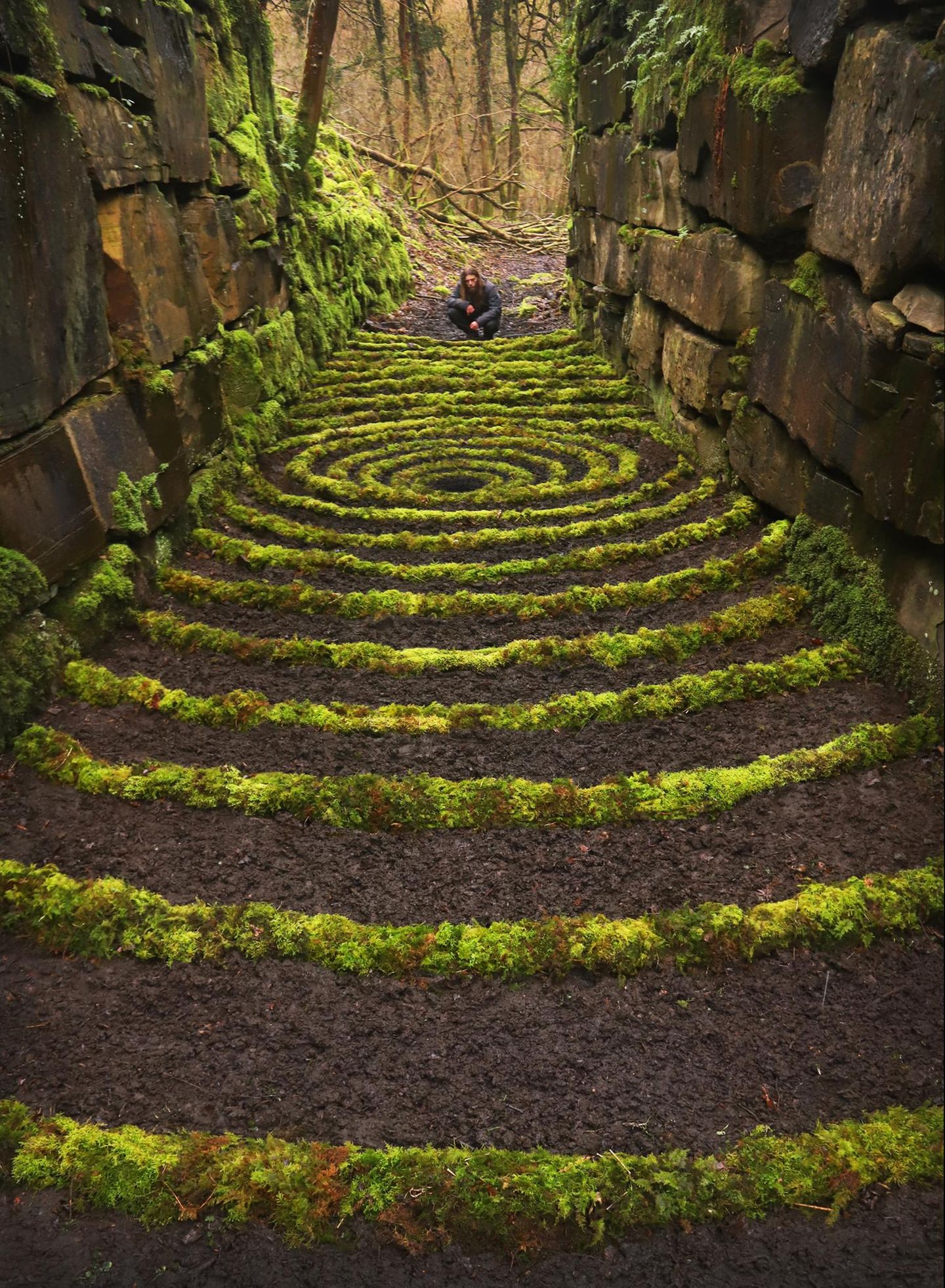 in einem Wald in Lancashire trafen sich die Land-Art-Künstler Jon Foreman, Layla Parkin und Mark Ford und kreierten zwischen den Mauern eines ehemaligen Steinbruchs aus Moos und Erde eine Treppe wie aus "Alice im Wunderland"