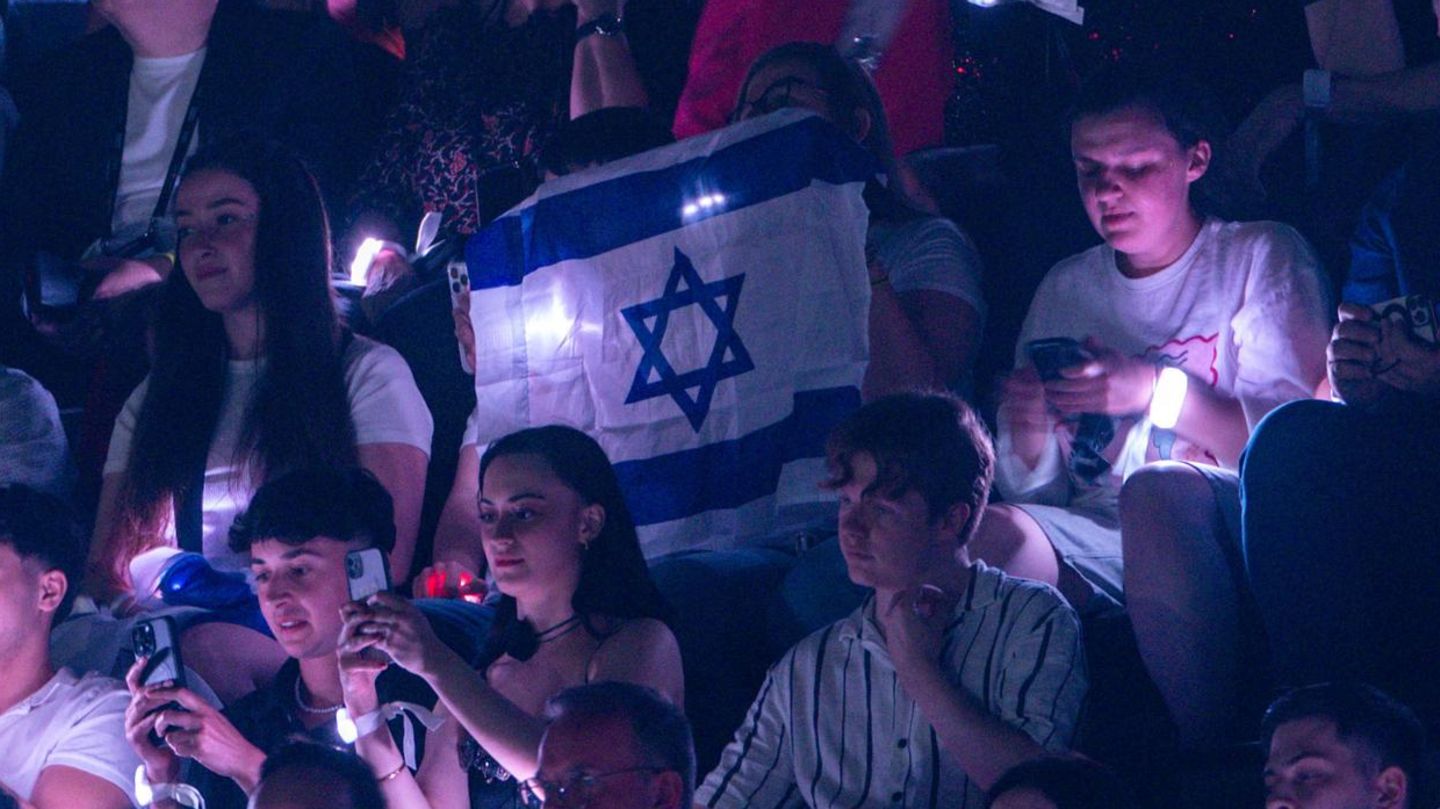 Musikfans halten israelische Fahnen beim ESC-Auftritt von Yuval Raphael in Basel