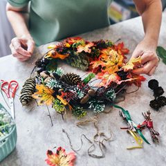 Person bastelt Türkranz als Herbstdeko für draußen