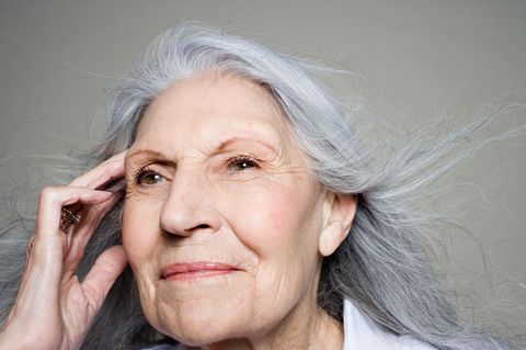 Gedankenübertragung/Telepathie :Frau fasst sich an die Schläfen und schaut in die Ferne