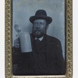 Ferrotypie auf dem ein Mann mit Hut auf dem Oktoberfest ein Trinkgefäß hochhält