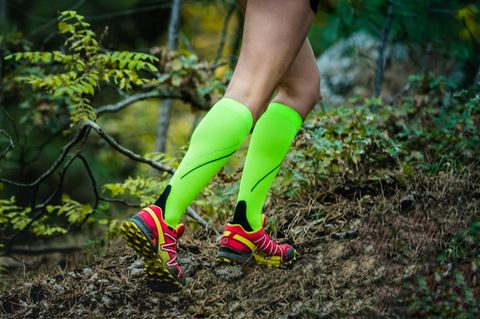 Eine Frau läuft mit Kompressionsstrümpfen durch den Wald