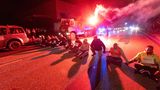 Hamburg, Deutschland. Mit Sitzblockade und Leuchtfackeln stoppen Demonstrierende eine Bundeswehr-Kolonne durch die Hansestadt. Doch hier sind keine politischen Aktivisten am Werk, sondern von der Manöverleitung eingesetzte Darsteller. Sie sollen den Schwierigkeitsgrad für die Teilnehmenden von Bundeswehr und Polizei noch einmal erhöhen