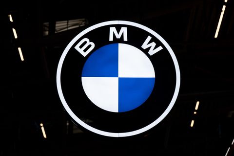 Das erleuchtete Logo von BMW hängt in einer Halle