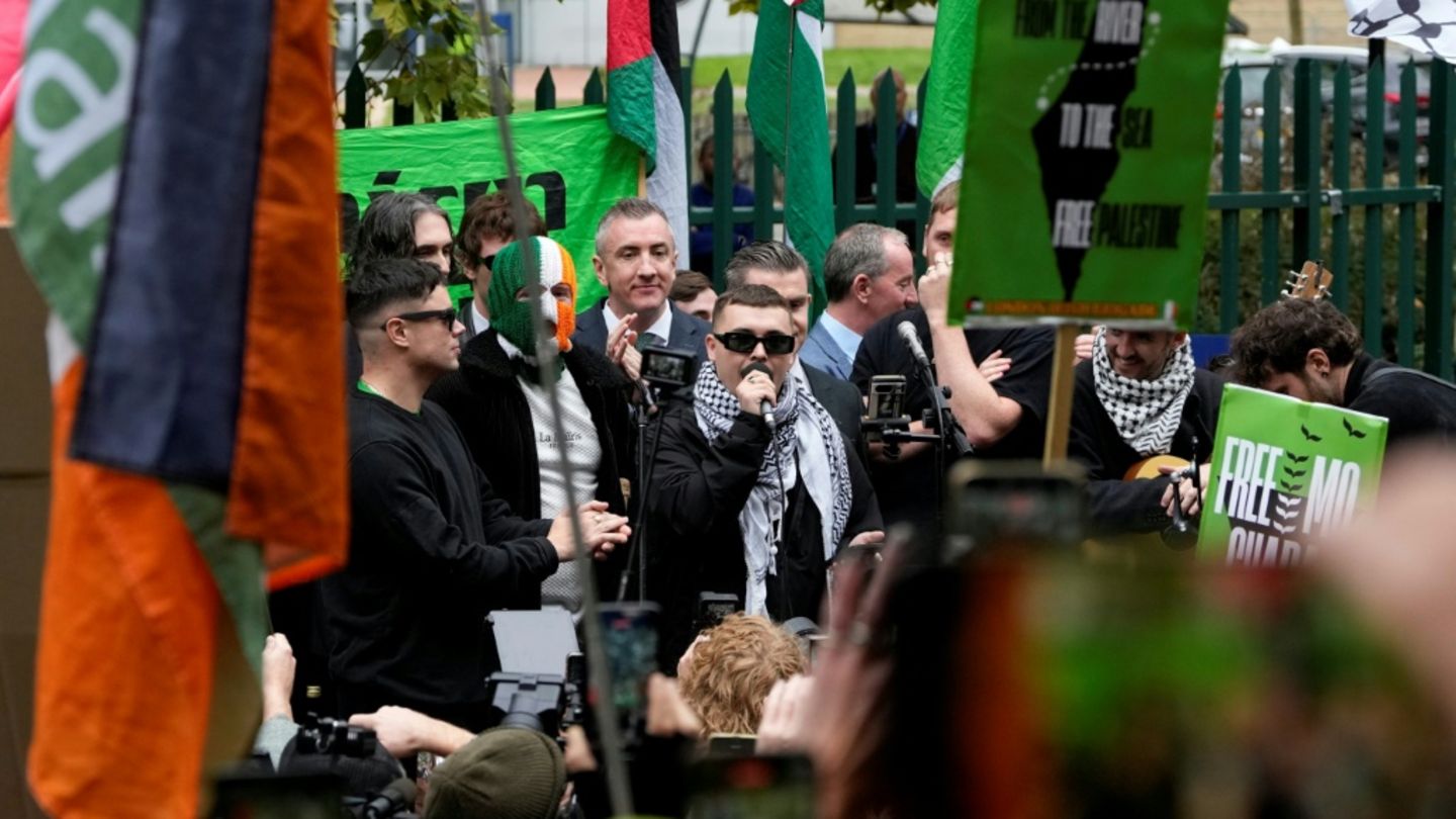 O'Hanna (M. mit Mikro) hält vor dem Gericht eine Rede vor Anhängern