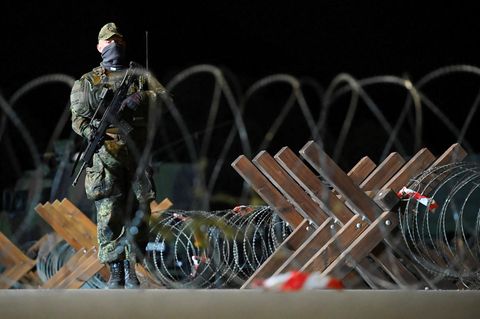 Ein Soldat der deutschen Bundeswehr bewacht während der Verteidigungsübung „Red Storm Bravo“ eine mit Stacheldraht abgesperrte Straße im Hamburger Hafen