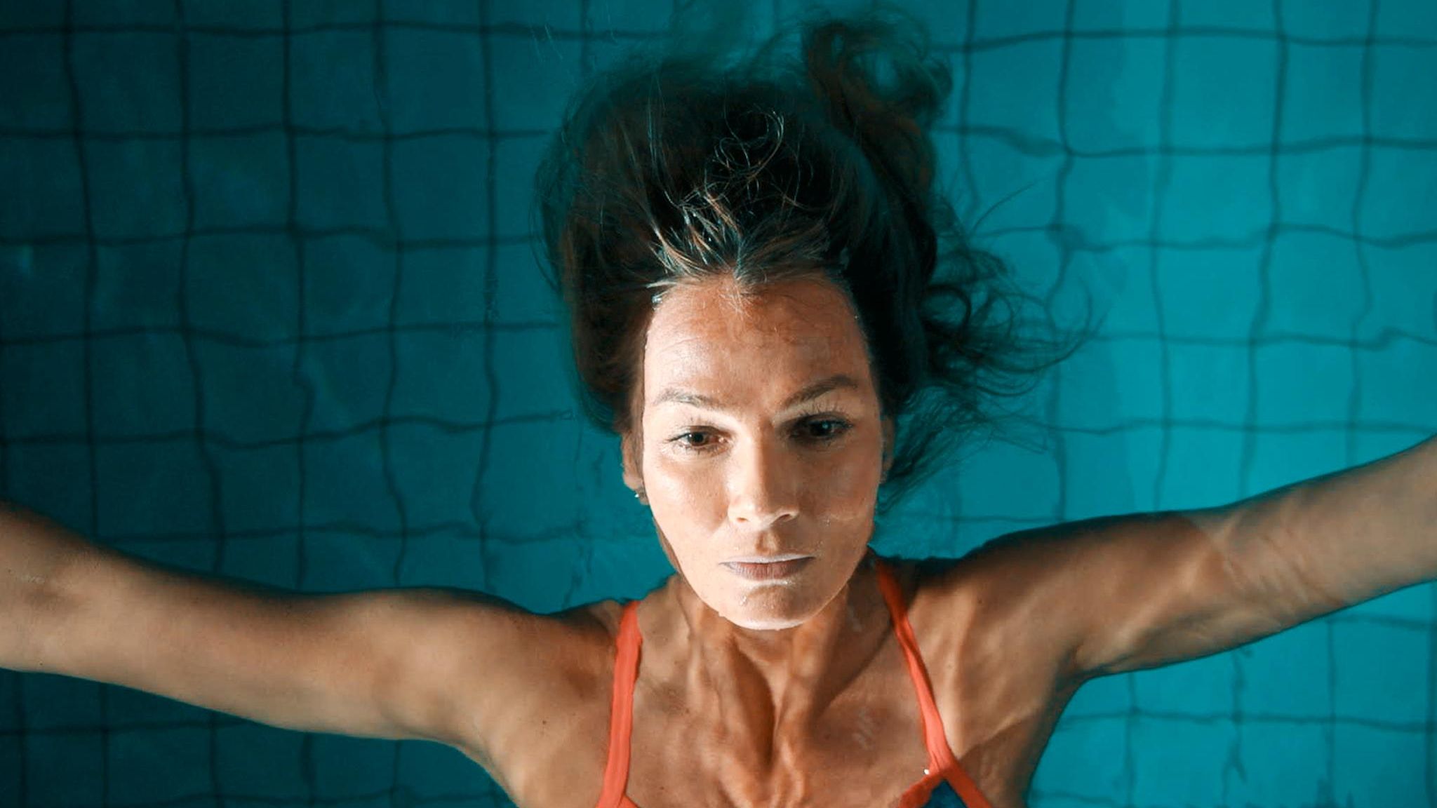 Franziska van Almsick treibt mit dem Rücken auf dem Wasser in einem Hallenbad