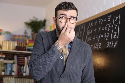 Ein Lehrer hält sich in der Schule die NAse zu