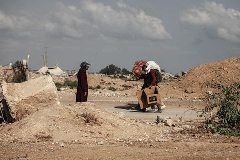 Zwei Palästinenser trotten durch karge Landschaft in Gaza