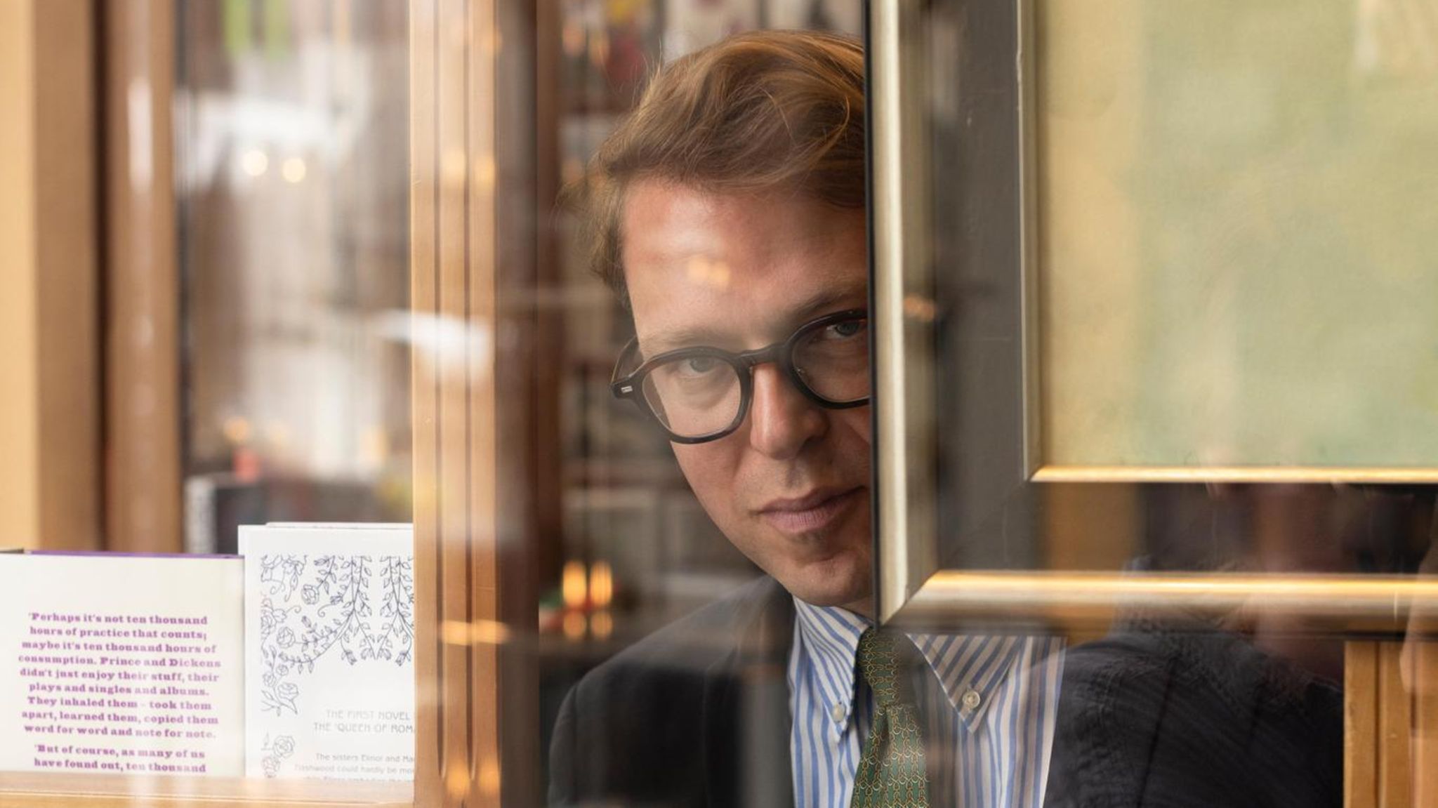 Robert Eberhardt schaut durch das Fenster seiner Buchhandlung