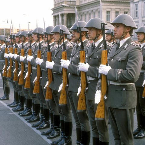 NVA-Soldaten in grauen Uniformen stehen in Reihe und Glied