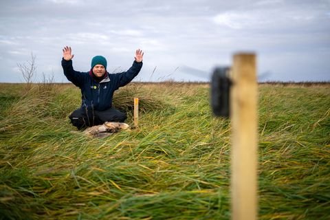 Benedikt Wiggering testet eine Wildtierkamera, die andere Tiere an einem toten, ausgelegten Reh in den Salzwiesen dokumentieren