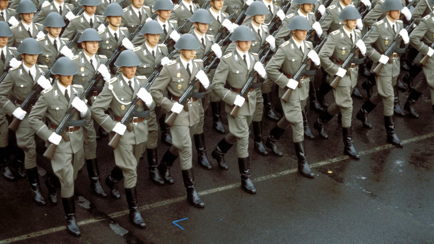 NVA-Soldaten marschieren mit Gewehr, Helm und Uniform