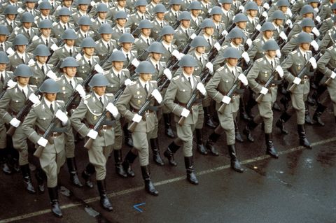 NVA-Soldaten marschieren mit Gewehr, Helm und Uniform