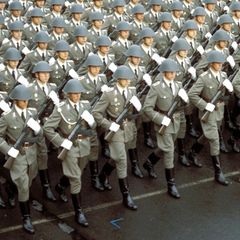 NVA-Soldaten marschieren mit Gewehr, Helm und Uniform