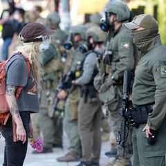 Bereits im Juli kam es in Portland zu Protesten gegen die Einwanderungsbehörde ICE. Hier steht eine Frau einem Polizeibeamten gegenüber, der ein Abzeichen des Special Response Teams des Houston Field Office trägt