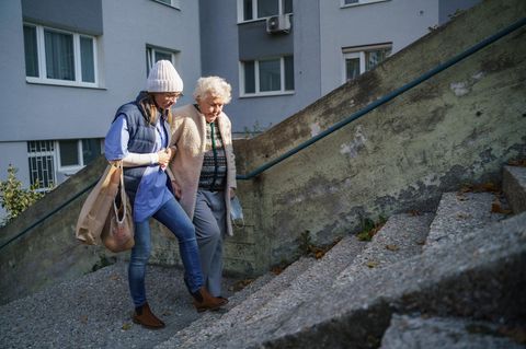 Eine Frau bringt mit einer älteren Dame die Einkäufe nach Hause