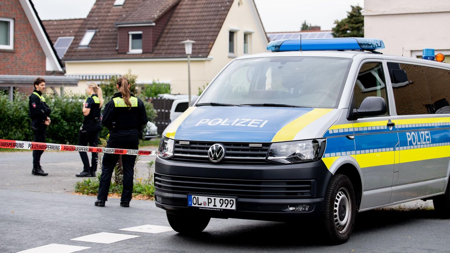 Polizisten stehen in einem mit Flatterband abgesperrten Bereich nahe des Tatorts in Oldenburg