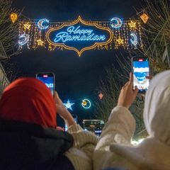 Passanten fotografieren mit ihren Handys die "Happy Ramadan" Beleuchtung