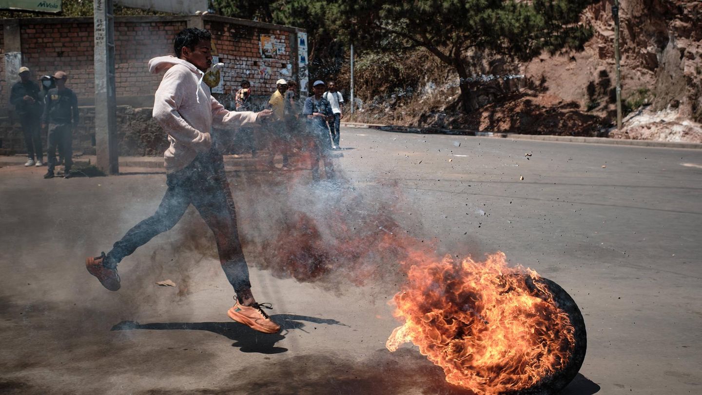 30. September: Feuerball Antananarivo, Madagaskar. Wütend und verzweifelt: Ein Demonstrant in der Hauptstadt bewegt einen brennenden Reifen in Richtung der Barrikaden, die von den Sicherheitskräften errichtet wurden. Präsident Andry Rajoelina hat die Regierung nach den von Jugendlichen angeführten Protesten gegen Wasser- und Stromausfälle aufgelöst. Nach Angaben der UNO wurden mindestens 22 Menschen getötet und mehr als 100 verletzt